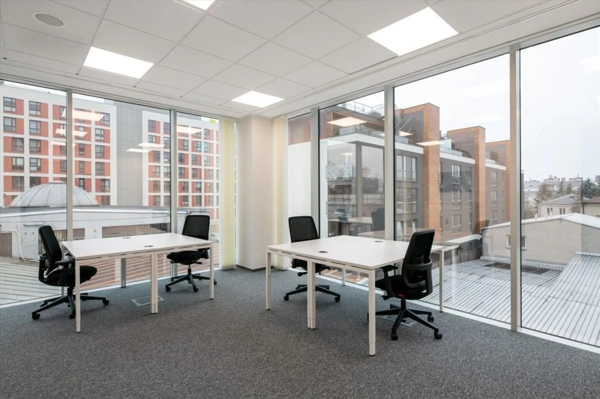 Spacious office suite at The District with white desks and expansive floor-to-ceiling windows.