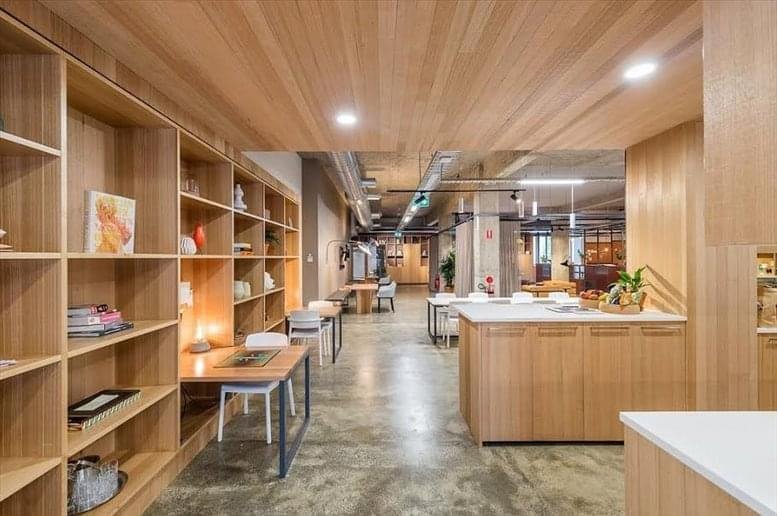 Spacious communal area at Takamatsu Plaza Building 3-4/F with wooden shelving and warm lighting.
