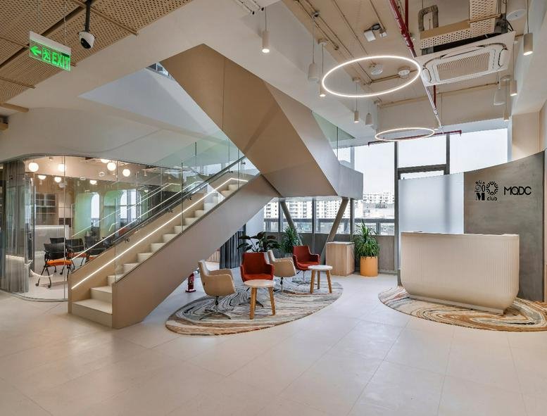 Spacious reception area and lobby at 4th Floor, Tapasya One featuring a grand staircase and modern lounge seating.