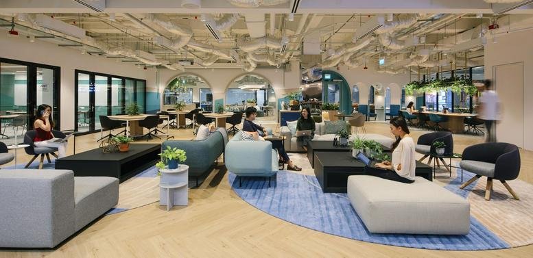 Spacious communal lounge at The Centrepoint, Levels 4 & 6, 176 Orchard Road, Singapore with modern sofas and exposed pipes.