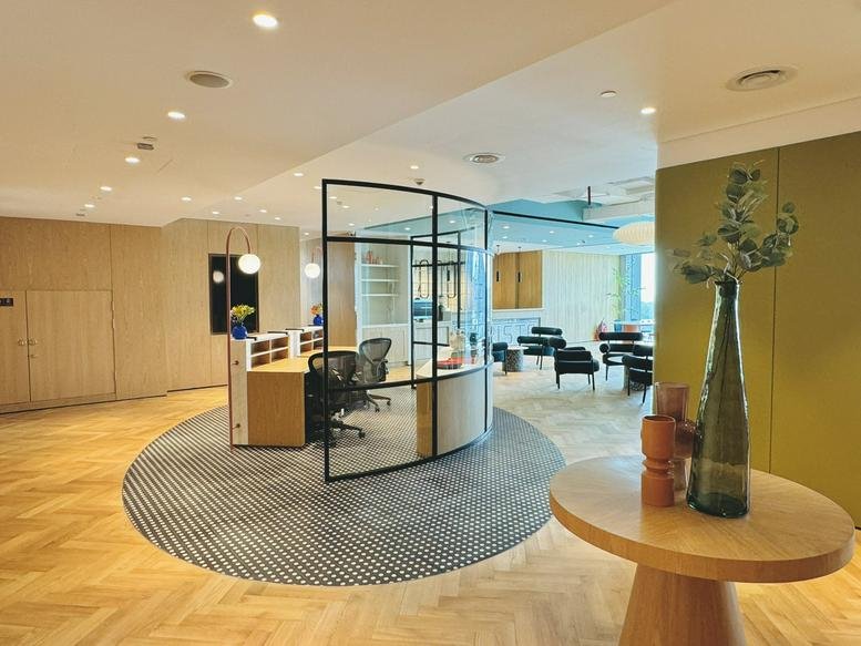 Bright reception area at The Nexus Tower featuring light wood paneling and a curved glass partition.