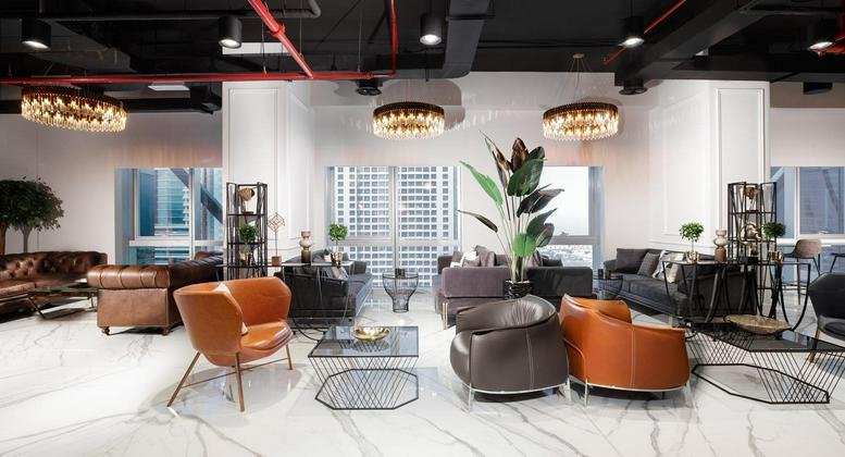 Spacious communal lounge at The One Tower, Sheikh Zayed Road, Dubai featuring modern armchairs and marble floors.