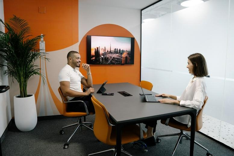 Bright conference room at The One Tower, Sheikh Zayed Road, Dubai with an orange accent wall.
