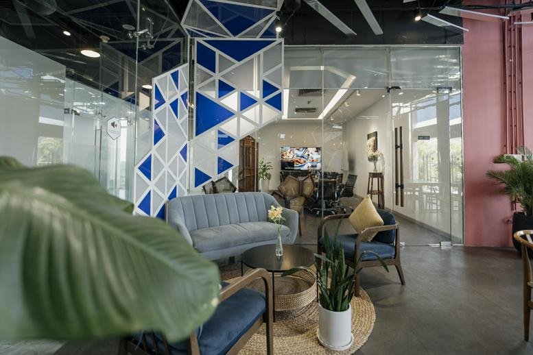 Spacious communal lounge at The Vista Building with blue sofas and a geometric glass feature wall.