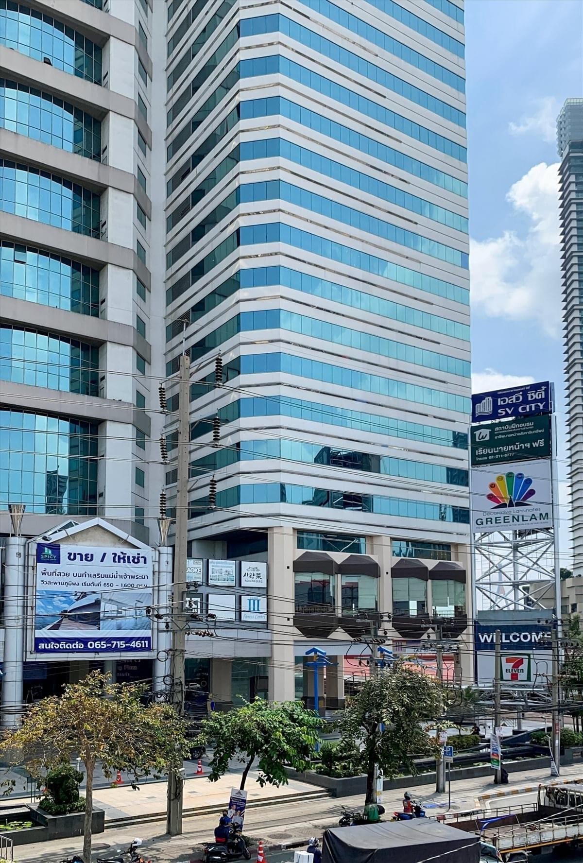 Exterior view of the glass-facade SV City Tower building complex under a bright sky.