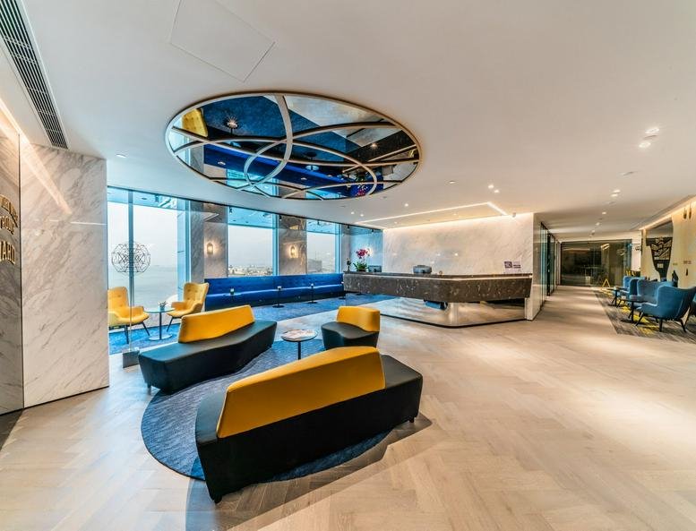 Modern reception lobby at Tower 5, The Gateway with a circular ceiling mirror and stylish lounge seating.