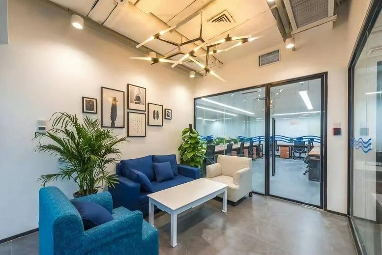 Spacious reception lounge at Hongfu Building with a blue sofa, white armchair, and stylish modern chandelier.