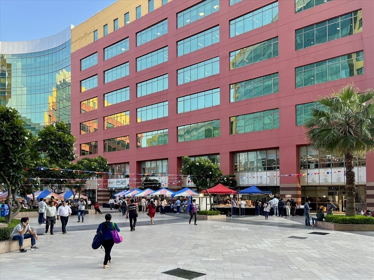 Exterior view of the multi-story red and glass facade of Unitech Cyber Park, Tower A.
