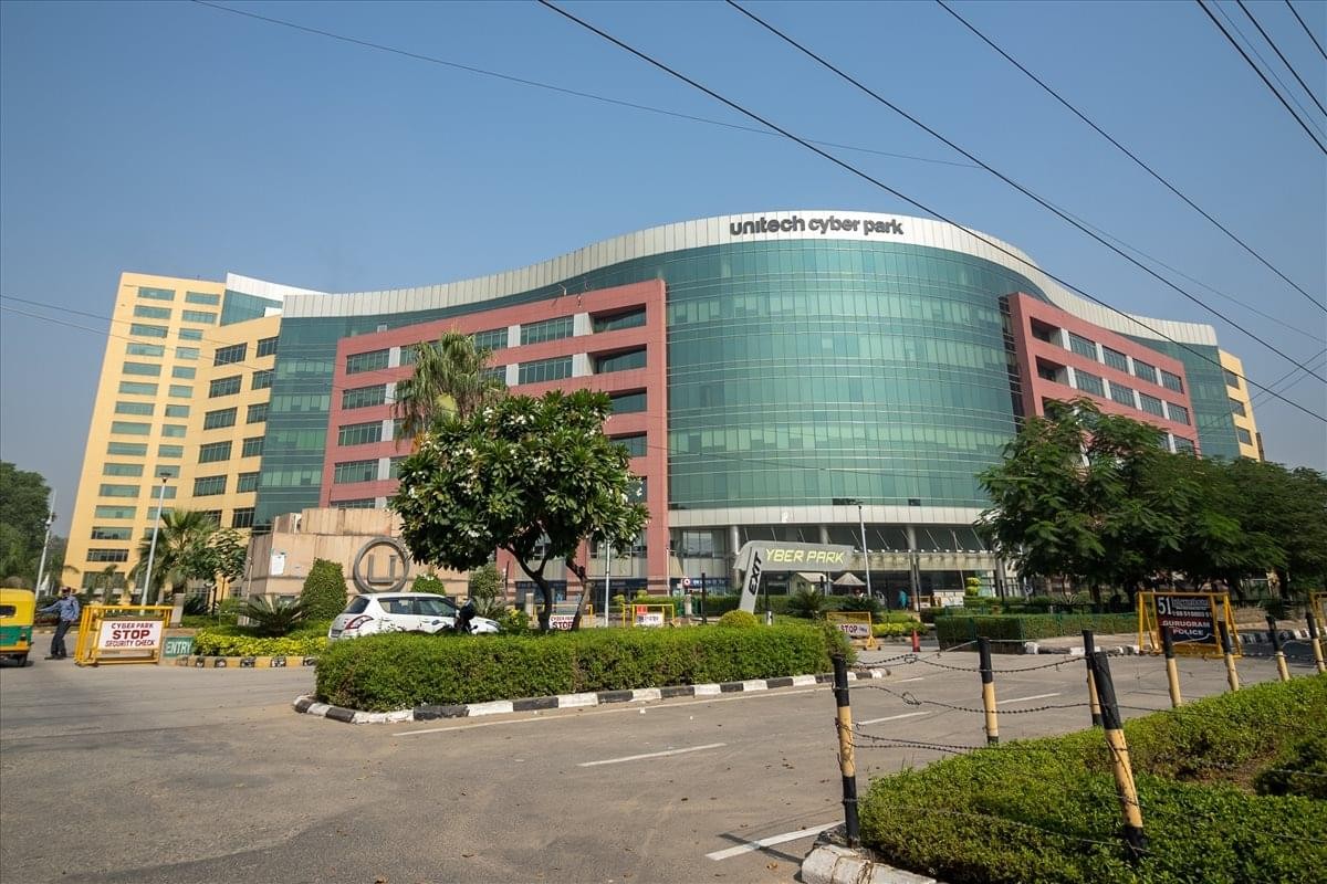 Exterior view of the curved glass facade of Tower-B Unitech Cyber Park.