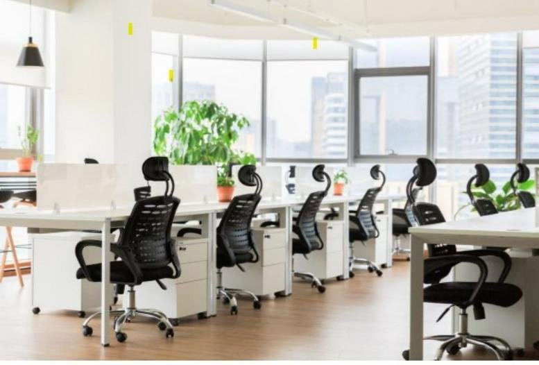 Open-plan workspace with multiple desks and city views.