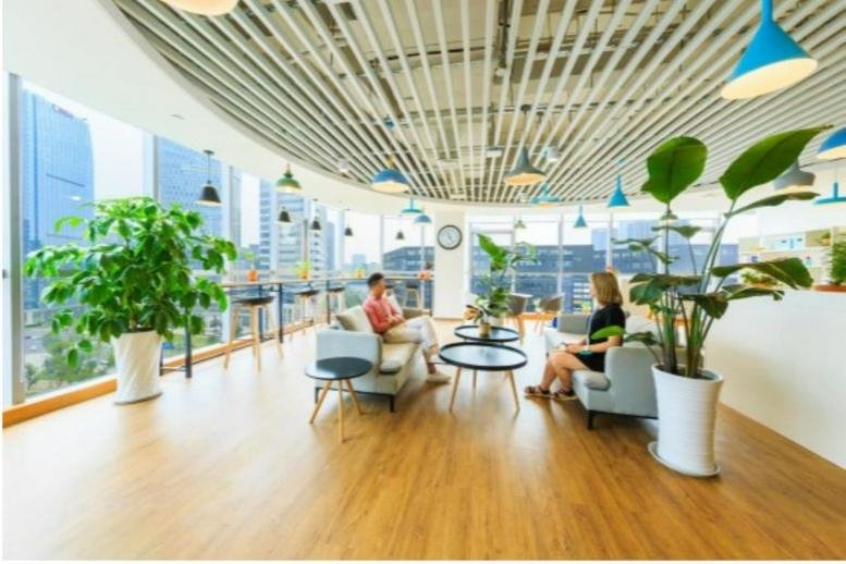 Spacious communal lounge at Ucommune Chengdu Yintai with wood floors and city views.