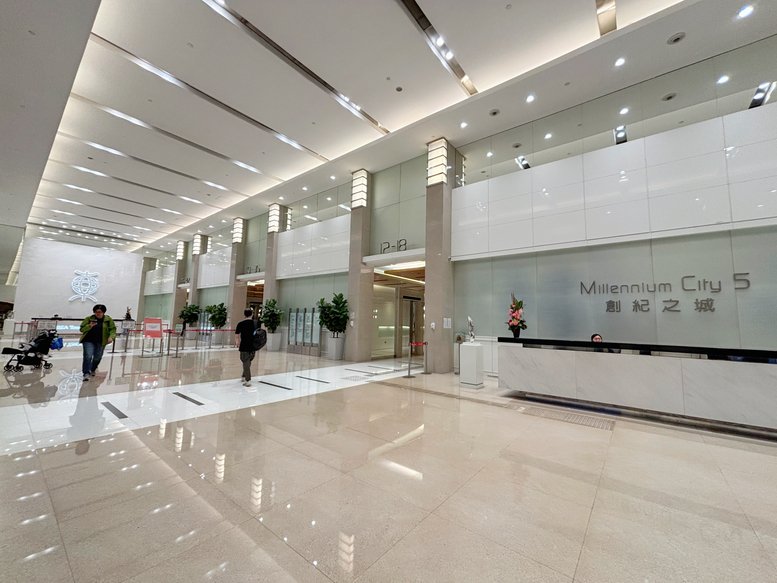 Grand building lobby with polished floors and a marble reception desk.