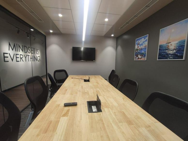 Professional meeting room featuring a long wooden table and framed wall art.