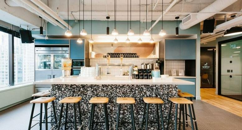 Spacious communal bar area at WeWork Landmark Center, 328 Tian Tong Lu with colorful stools and pendant lighting.
