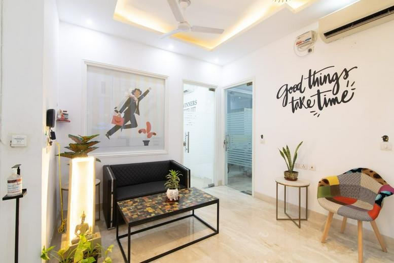 Bright reception area at Sunrise Tower with a modern black sofa and motivational wall art.