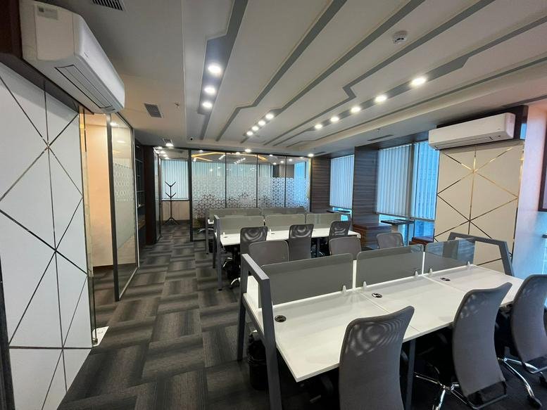 Professional workspace at WP-477, Sunrise Tower with modern desks and geometric ceiling designs.