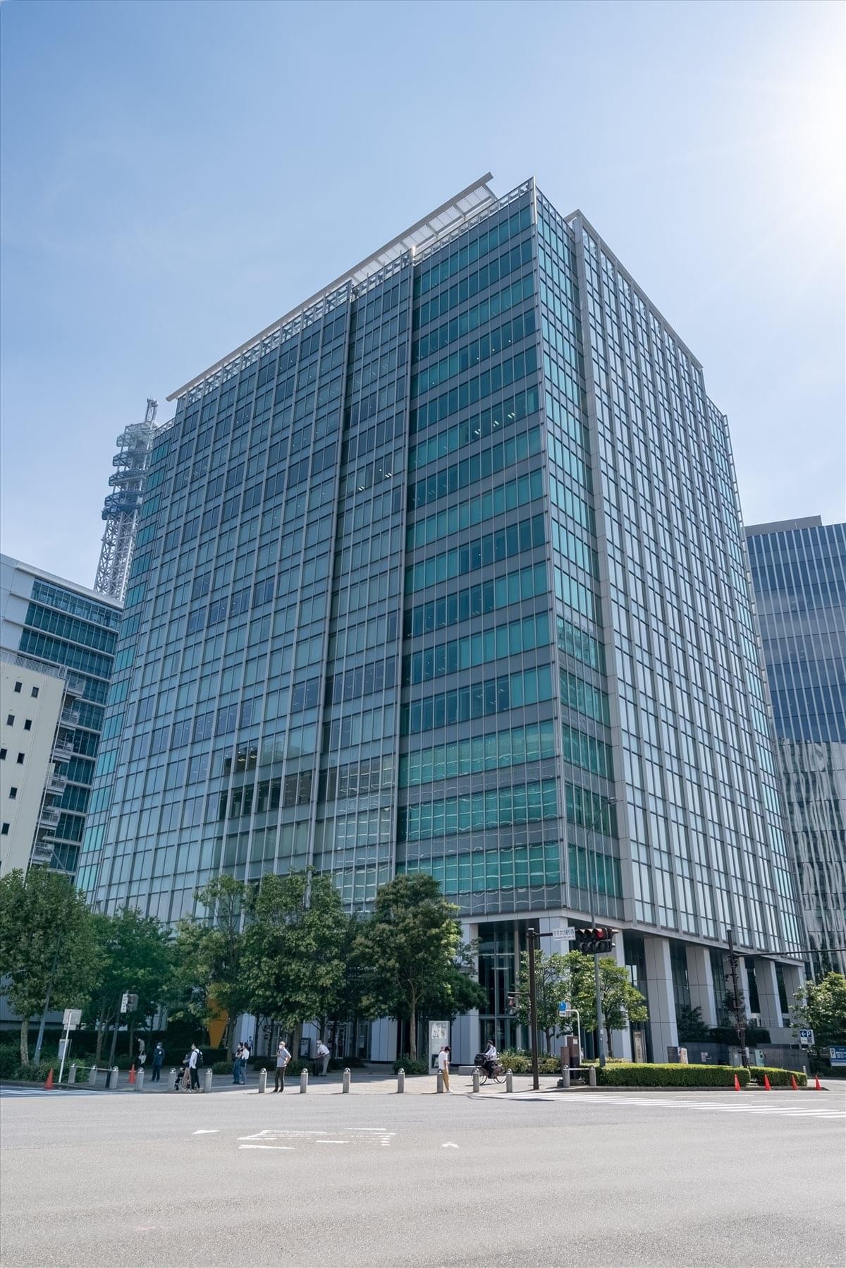 Exterior view of the glass-facade Yokohama Blue Avenue building under a clear sky.