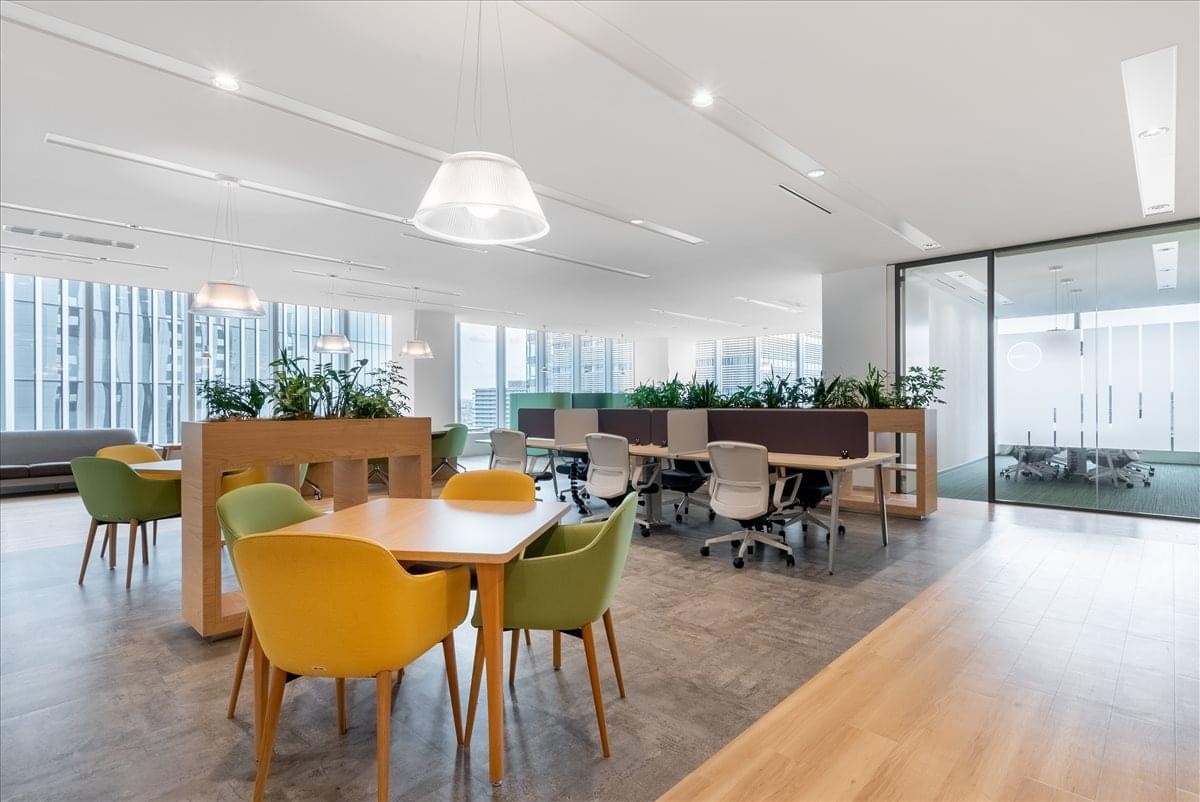 Spacious communal lounge area with diverse seating options and integrated indoor plants.