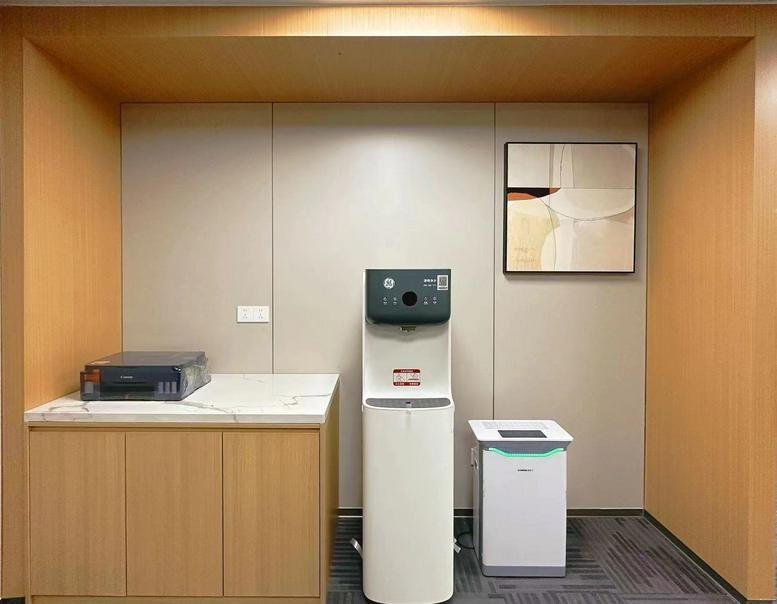Communal break area at Yutong International Sports Center featuring a water dispenser, storage, and wall art.