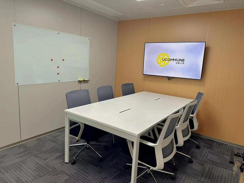 Meeting room at Yutong International Sports Center with a white table and wall-mounted screen.