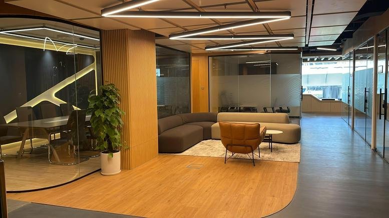 Spacious communal lounge at Sheikh Zayed Road, Business Bay Metro station with warm wood floors and designer seating.