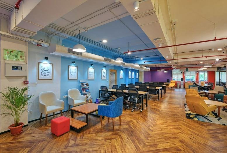 Spacious communal lounge at Shubharam Complex,144, Mahatma Gandhi Road with colorful seating and herringbone floors.