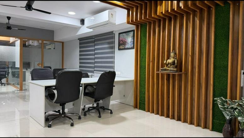 Bright workspace at Skywalk The Element, Jagatpur featuring a decorative wood slat wall with a Buddha statue.