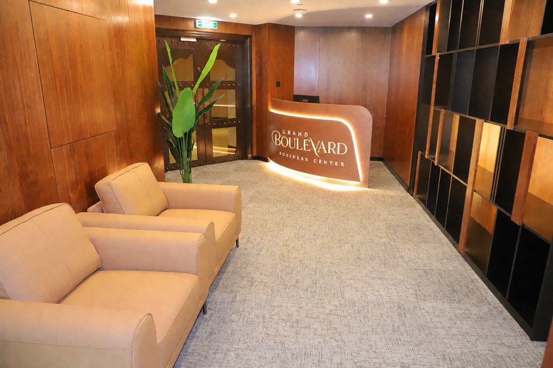 Lobby and reception area at Souk, Al Saaha Offices Block B with warm wood paneling and leather armchairs.
