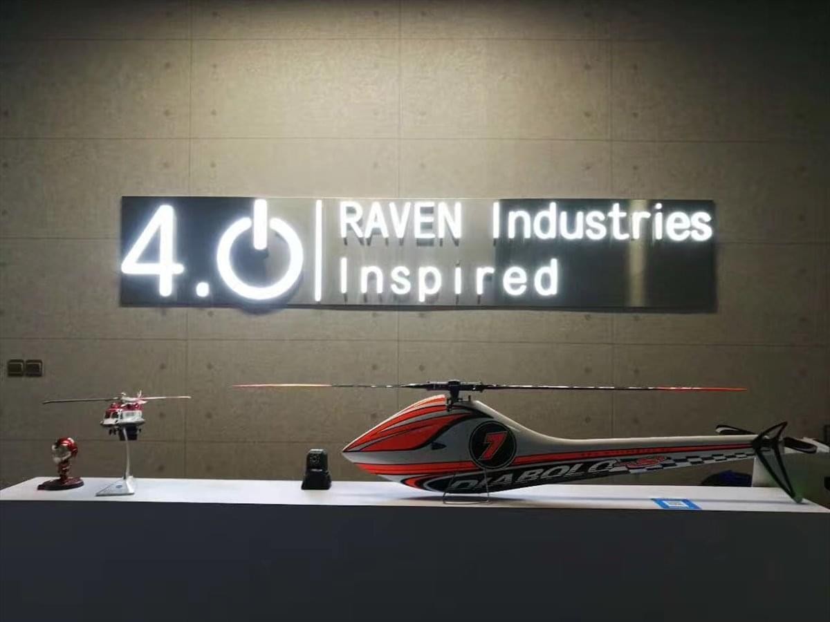 Reception area at Block B, 21 Shihua Road with drone models and a lit logo for Raven Industries.