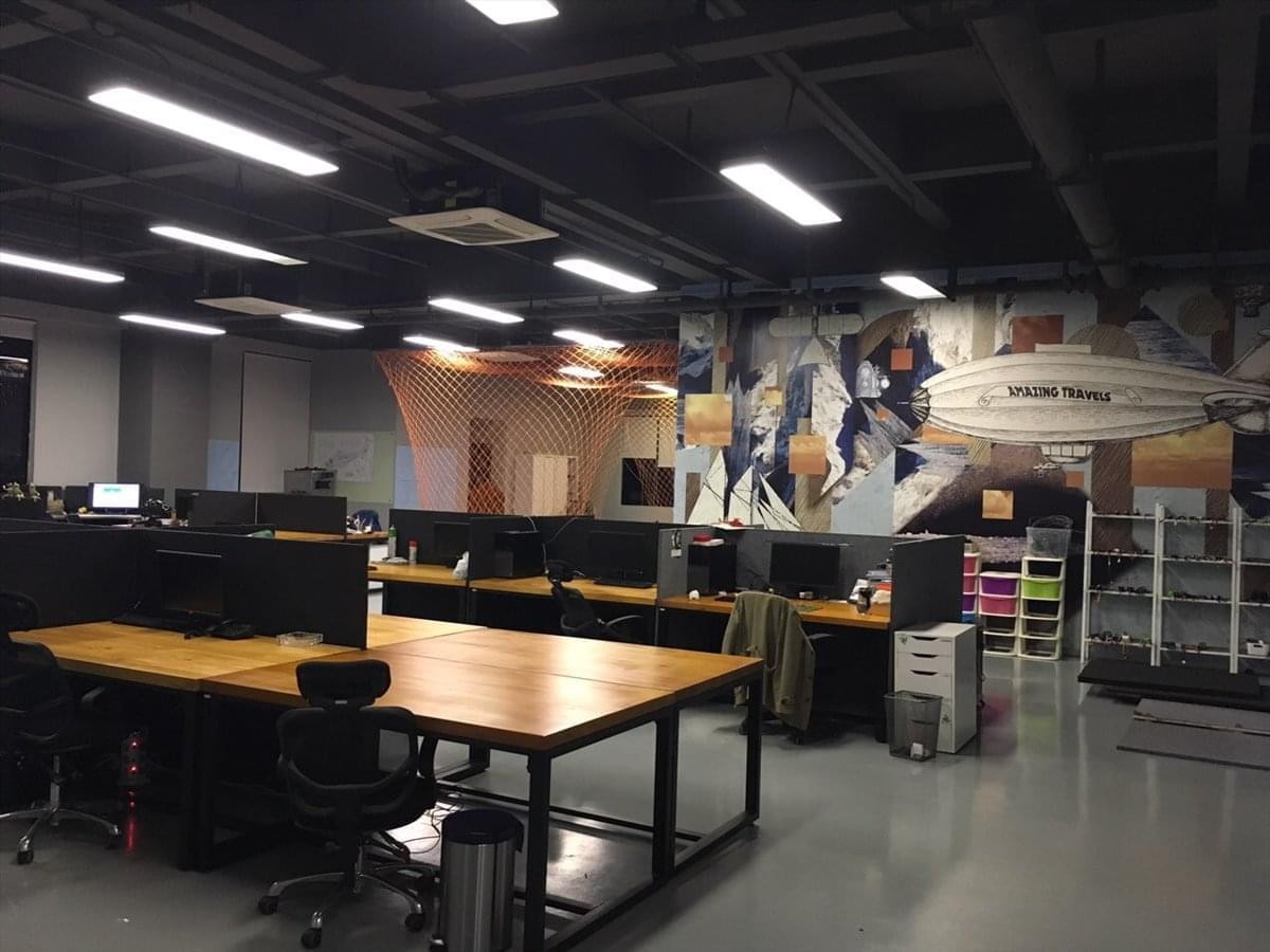 Spacious open-plan workspace at Block B, 21 Shihua Road with wooden desks and industrial ceiling design.