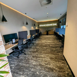 Workplace with multiple desks and ergonomic chairs in a dynamic design zone.