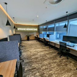 Open-plan workspace with window-side desks and partition screens.