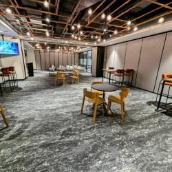 Modern café-style breakout area with multiple seating options and plants.