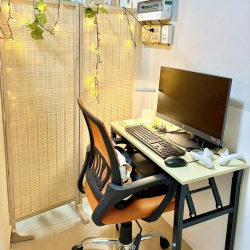 Private workstation with an orange ergonomic chair and a light-up woven privacy screen.