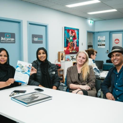 Casual break-out area with team members collaborating at a white table.