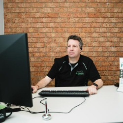 Dedicated workstation with a brick wall background and dual monitor setup.