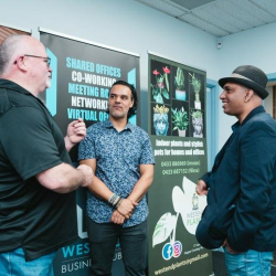 Professional networking area with branded banners and people engaging in conversation.