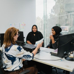 Modern office workspace with large windows and multiple computer stations.