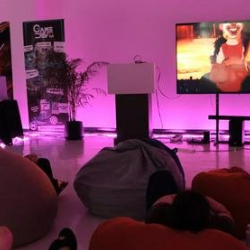 Creative event space with bean bag seating and a large display screen.