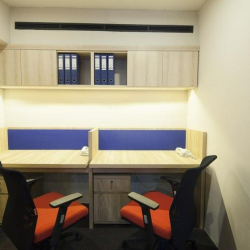 Private two-person office suite with bright orange chairs and blue privacy screens
