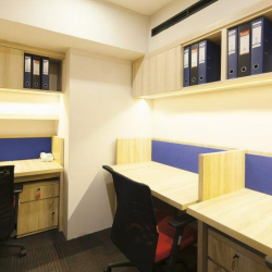 Three-person office unit with light wood desks and blue upholstered dividers