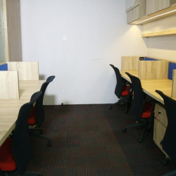 Open-plan office corridor with rows of ergonomic workstations and blue accents