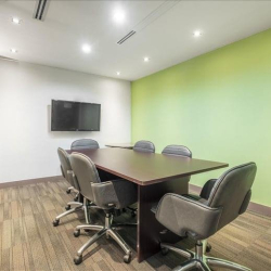 Professional meeting room featuring a dark wood table and green wall, Wan Chai, Hong Kong.