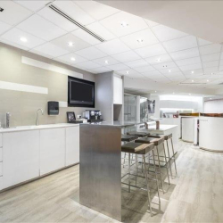 Bright breakout area with kitchen counter and modern pod seating, Wan Chai, Hong Kong.