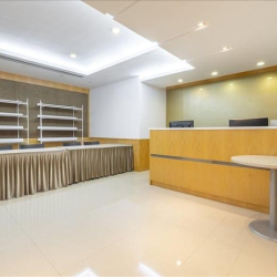 Reception desk area with wooden finishes and clean white walls, Wan Chai, Hong Kong.