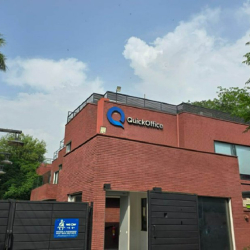 Exterior view of QuickOffice | 304 Upper Mall, Lahore, with its red brick facade and blue brand logo.