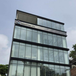 Contemporary office building with a sleek glass-walled facade and upper-level branding.