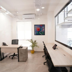Functional office room featuring a work desk and a large floor-to-ceiling whiteboard wall.