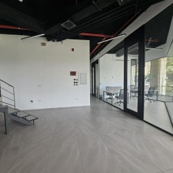 Modern interior workspace at V Business Center Abdali Boulevard, Amman featuring glass walls and industrial ceilings.