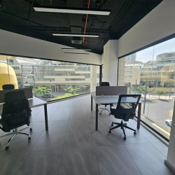 Clean office space with a desk and a large window overlooking the street.